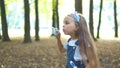 Happy little child girl blowing soap bubbles outside in green park. Outdoor summer activities for children concept Royalty Free Stock Photo
