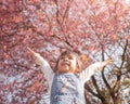 Happy little child girl enjoying with nature in the park on sunshine day in springtime. Royalty Free Stock Photo