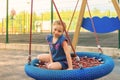 Happy little child girl laughing and swinging on a swing in the city park in summer Royalty Free Stock Photo