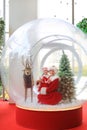 Happy little child girl and mother in santa costume dress has fun in big winter Snow globe with reindeer on christmas time. Merry Royalty Free Stock Photo