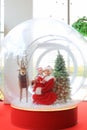 Happy little child girl and mother in santa costume dress has fun in big winter Snow globe with reindeer on christmas time. Merry Royalty Free Stock Photo