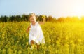 Happy little child girl running on field with yellow flowers Royalty Free Stock Photo