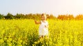 Happy little child girl running on field with yellow flowers Royalty Free Stock Photo