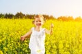 Happy little child girl running on field with yellow flowers Royalty Free Stock Photo