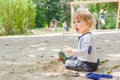 Happy little child having fun playing with sand and colorful toys in the park, beautiful summer sunny day in children playground Royalty Free Stock Photo