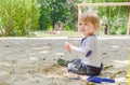 Happy little child having fun playing with sand and colorful toys in the park, beautiful summer sunny day in children playground Royalty Free Stock Photo