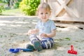 Happy little child having fun playing with sand and colorful toys in the park, beautiful summer sunny day in children playground Royalty Free Stock Photo