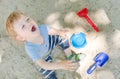 Happy little child having fun playing with sand and colorful toys in the park, beautiful summer sunny day in children playground Royalty Free Stock Photo