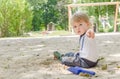 Happy little child having fun playing with sand and colorful toys in the park, beautiful summer sunny day in children playground Royalty Free Stock Photo