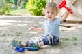 Happy little child having fun playing with sand and colorful toys in the park, beautiful summer sunny day in children playground Royalty Free Stock Photo