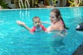 Happy little child with mother, Baby first time in a large pool and very impressed. Infant very happy, with open mouth, Teaching Royalty Free Stock Photo