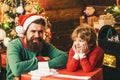 Happy little child son with father dressed in winter clothing think about Santa near Christmas tree. Christmas family Royalty Free Stock Photo