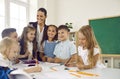 Happy little children learning draw in elementary school stand in classroom with woman teacher Royalty Free Stock Photo