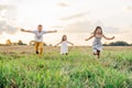 Happy little children play together and run forward across field waving arms wide. Carefree kids on grassy meadow. Royalty Free Stock Photo