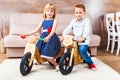 Happy little children riding a runbikes at home Royalty Free Stock Photo