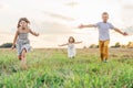 Happy little children run forward across field waving arms wide. Carefree kids on grassy meadow. Summer vacation. Royalty Free Stock Photo