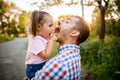 Happy little cute girl sits in her father`s arms and having fun Royalty Free Stock Photo