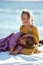 Happy little cute girls enjoying sunny day at the beach, hugging and smiling to the camera. Family summer vacation. Sister`s love Royalty Free Stock Photo