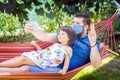 Happy little daughter in father arms taking selfie while relaxing in hammock Royalty Free Stock Photo