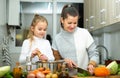 Happy little daughter and woman preparing vegetable soup Royalty Free Stock Photo