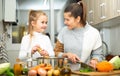 Happy little daughter and woman preparing vegetable soup Royalty Free Stock Photo