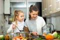Happy little daughter and woman preparing vegetable soup Royalty Free Stock Photo