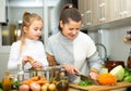 Happy little daughter and woman preparing vegetable soup Royalty Free Stock Photo