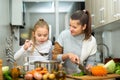 Happy little daughter and woman preparing vegetable soup Royalty Free Stock Photo