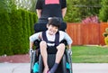 Happy little disabled boy outdoors in wheelchair Royalty Free Stock Photo