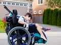 Happy little disabled boy outdoors in wheelchair