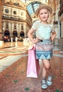 Happy little fashion monger with pink shopping bag in Galleria