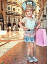 Happy little fashion monger with pink shopping bag in Galleria