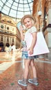 Happy little fashion monger with pink shopping bag hand waving