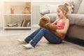 Happy little female child hugging her teddy bear on the floor at home Royalty Free Stock Photo