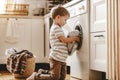 Happy householder child boy in laundry with washing machine