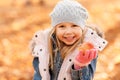 Happy little girl with apple at autumn park Royalty Free Stock Photo