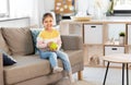 Happy little girl with apple sitting on sofa Royalty Free Stock Photo