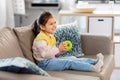 Happy little girl with apple sitting on sofa Royalty Free Stock Photo