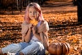 Happy little girl in autumn clothes on an autumn background. A smiling child is playing in fall park. Young Royalty Free Stock Photo