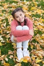 Happy little girl in autumn forest. Autumn leaves and nature. Small child with autumn leaves. Happy childhood. School