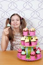 Little girl with besmear face and muffins cakes