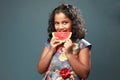 A little girl bites a slice of watermelon