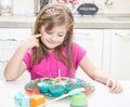 Happy little girl blowing out the birthday candle on the cake muffins Royalty Free Stock Photo