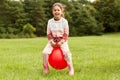 happy little girl bouncing on hopper ball at park Royalty Free Stock Photo