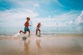 Happy little girl and boy run and play with water at beach Royalty Free Stock Photo