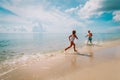 Happy little girl and boy run and play with water at beach Royalty Free Stock Photo