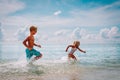 Happy little girl and boy run and play with water at beach Royalty Free Stock Photo