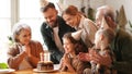 Happy little girl celebrating birthday with family at home, looking at cake with lit candles Royalty Free Stock Photo