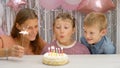 Happy little girl celebrating her birthday with family blowing out the candles on her cake. her family  watching little child Royalty Free Stock Photo