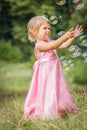 Happy little girl chasing bubbles on nature in the park Royalty Free Stock Photo